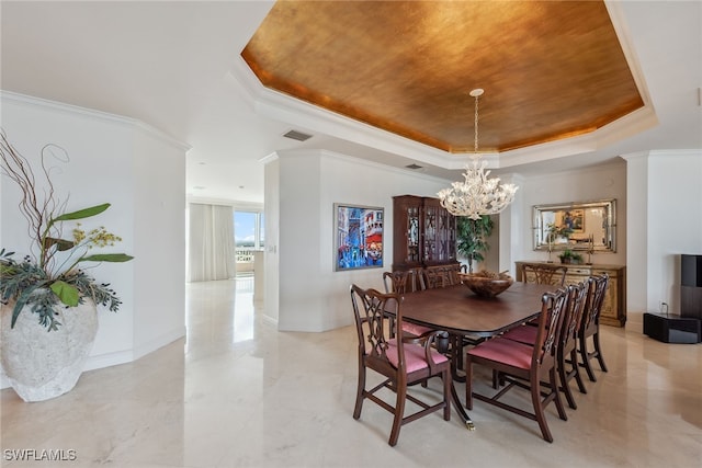 dining room with a tray ceiling, ornamental molding, and an inviting chandelier