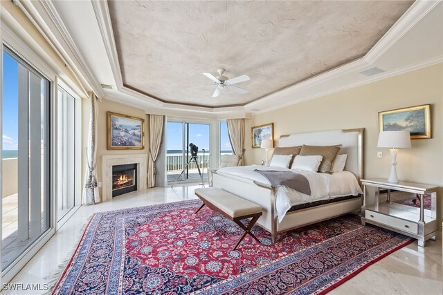 bedroom with ceiling fan, access to exterior, crown molding, and a tray ceiling