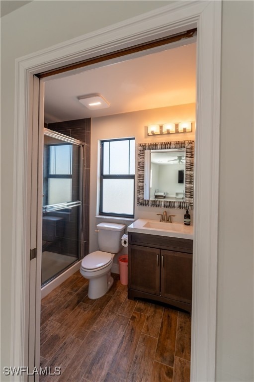 bathroom with vanity, hardwood / wood-style floors, toilet, and an enclosed shower