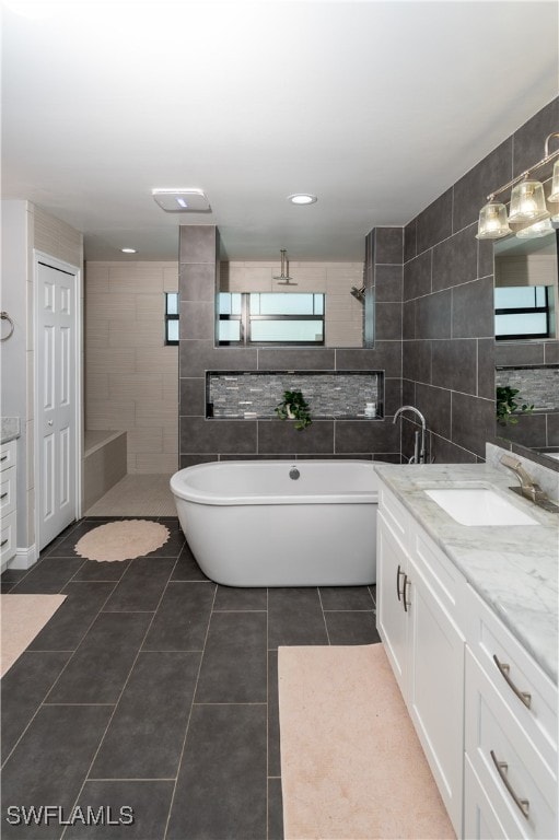 bathroom featuring vanity, tile patterned floors, tile walls, and independent shower and bath