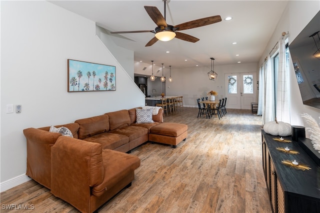 living room with sink, light hardwood / wood-style floors, and ceiling fan