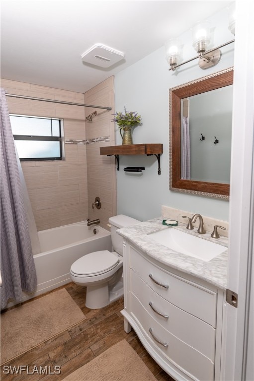 full bathroom featuring toilet, hardwood / wood-style floors, shower / bath combo, and vanity