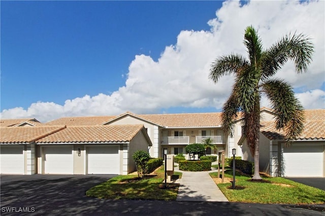 view of front of property featuring a garage and a balcony