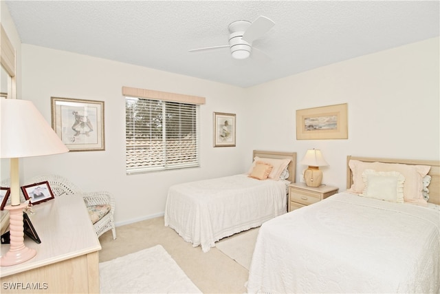 carpeted bedroom featuring ceiling fan and a textured ceiling