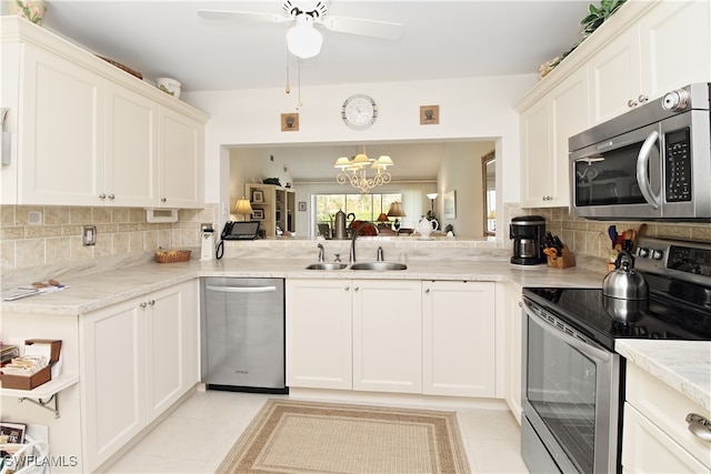 kitchen with sink, white cabinetry, light tile patterned floors, appliances with stainless steel finishes, and backsplash