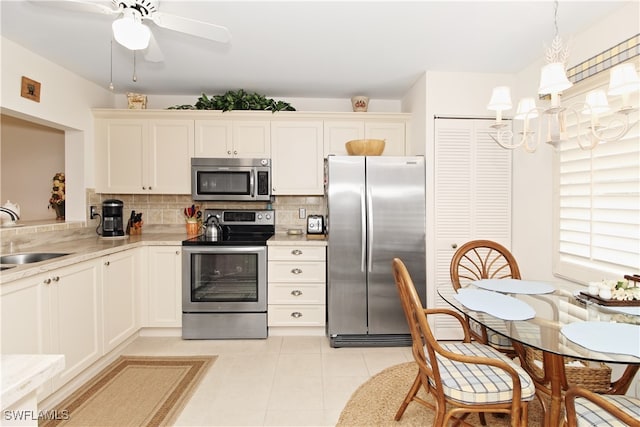 kitchen featuring sink, decorative light fixtures, appliances with stainless steel finishes, decorative backsplash, and white cabinets