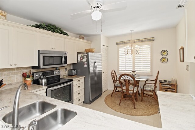 kitchen featuring sink, tasteful backsplash, light tile patterned floors, appliances with stainless steel finishes, and pendant lighting