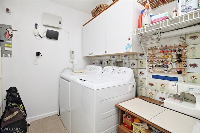 clothes washing area with cabinets and washer and dryer