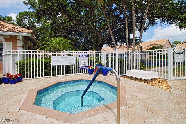 view of swimming pool with a hot tub