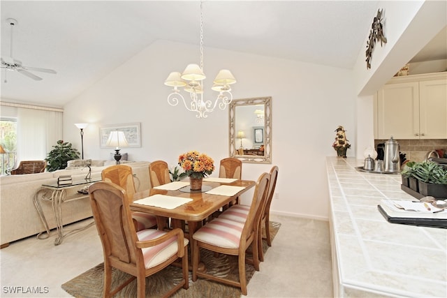 dining room featuring ceiling fan with notable chandelier, vaulted ceiling, and light carpet