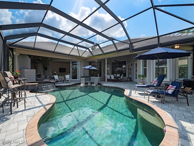 view of pool featuring a patio, glass enclosure, and ceiling fan