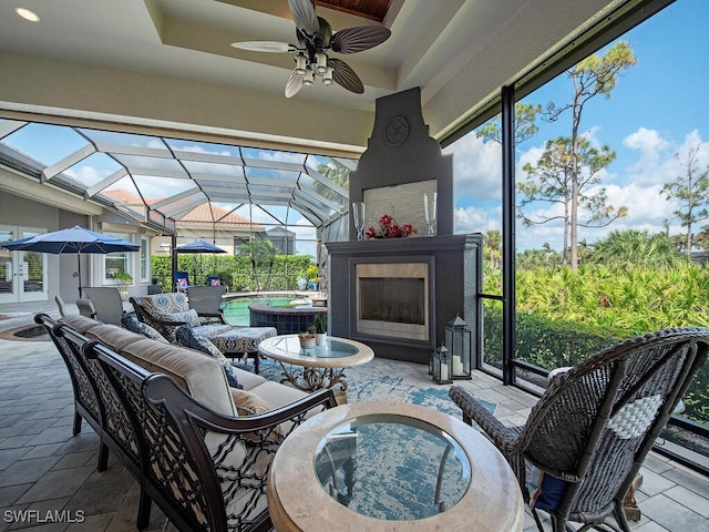 sunroom with vaulted ceiling, exterior fireplace, and ceiling fan