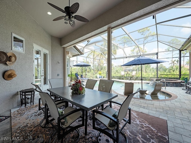 view of patio with an in ground hot tub, ceiling fan, and a lanai