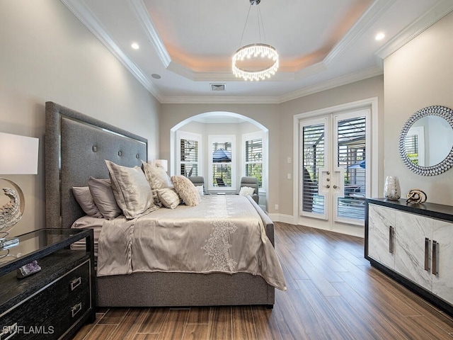 bedroom featuring crown molding, a tray ceiling, dark hardwood / wood-style flooring, and access to exterior