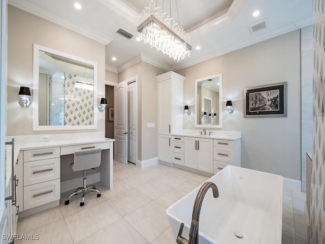 bathroom with tile patterned floors, a tub, ornamental molding, an inviting chandelier, and vanity