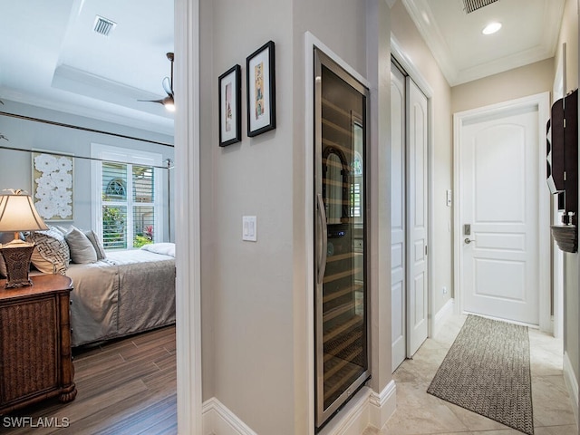 hall with ornamental molding and light hardwood / wood-style flooring