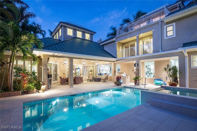 back house at dusk featuring outdoor lounge area, a patio area, a balcony, and area for grilling