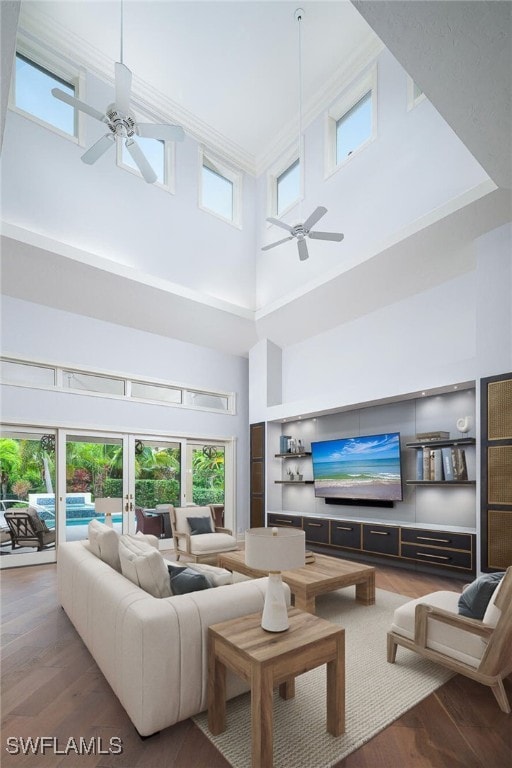 living room with ceiling fan, french doors, a high ceiling, and hardwood / wood-style flooring