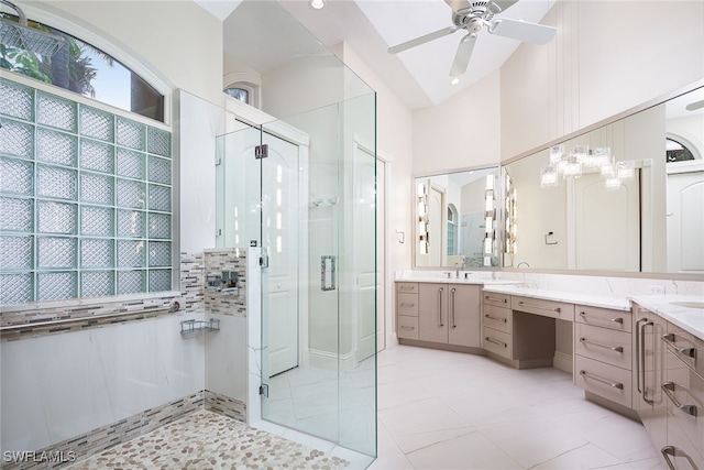 bathroom featuring ceiling fan, vanity, a shower with shower door, and vaulted ceiling