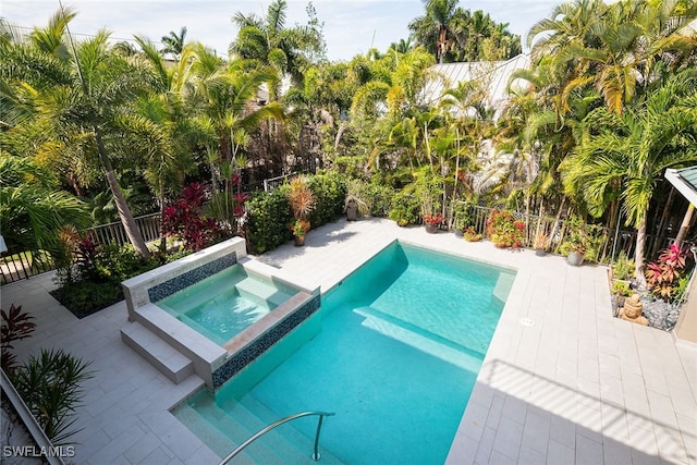 view of pool with a patio area and an in ground hot tub