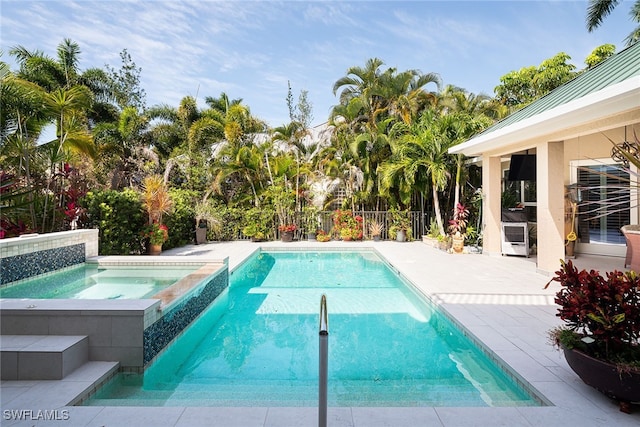 view of pool featuring a patio area and an in ground hot tub