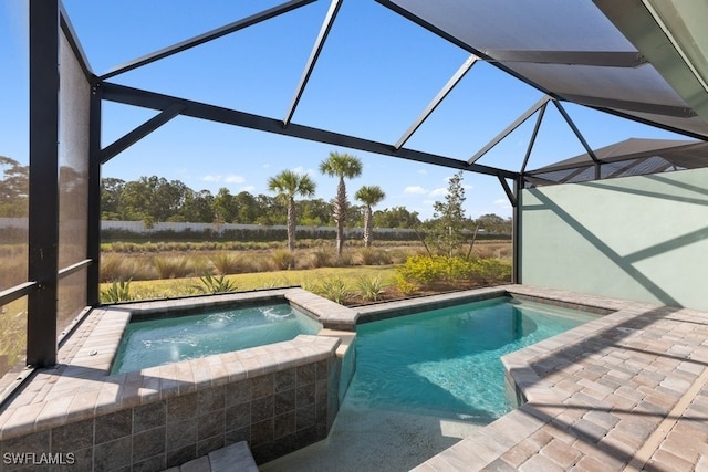 view of swimming pool featuring an in ground hot tub, a patio area, and a lanai