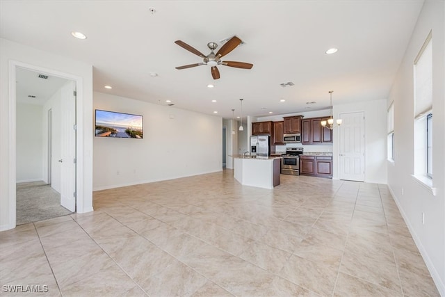 unfurnished living room with ceiling fan with notable chandelier