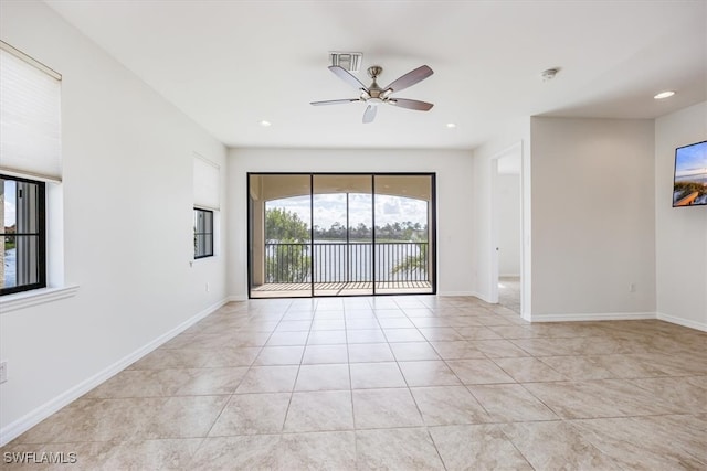 tiled spare room featuring ceiling fan