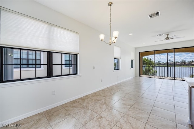 tiled empty room featuring ceiling fan with notable chandelier