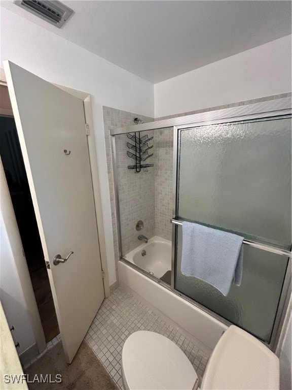 bathroom with enclosed tub / shower combo and toilet