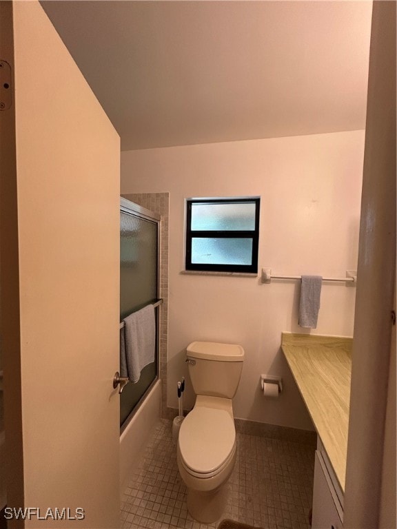 full bathroom featuring combined bath / shower with glass door, tile patterned floors, vanity, and toilet