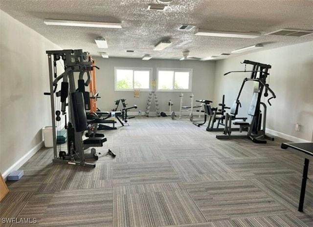 workout area with a textured ceiling and carpet floors