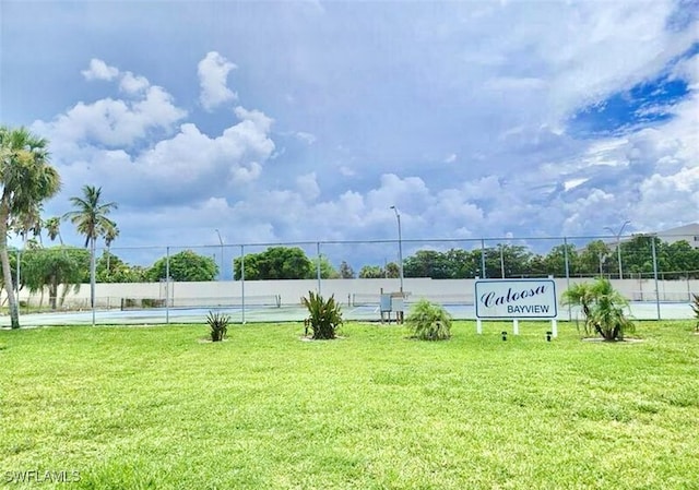 surrounding community featuring a lawn and tennis court