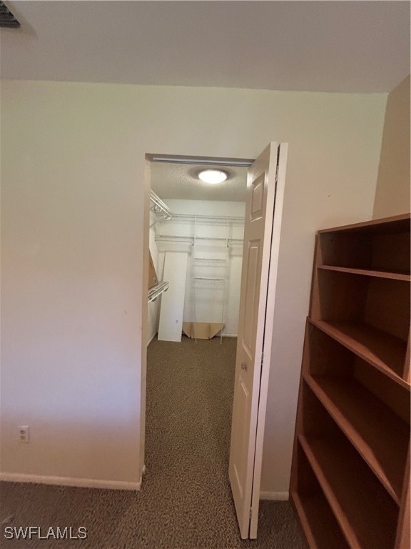 spacious closet featuring dark carpet