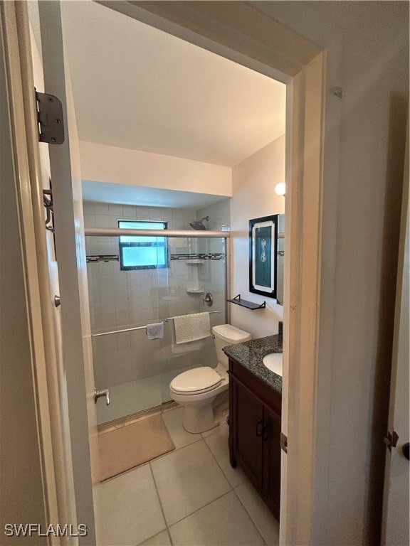 bathroom with toilet, an enclosed shower, vanity, and tile patterned flooring