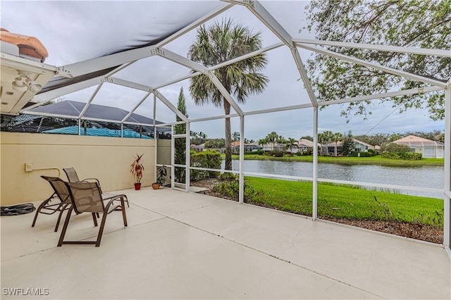 view of patio / terrace featuring glass enclosure and a water view