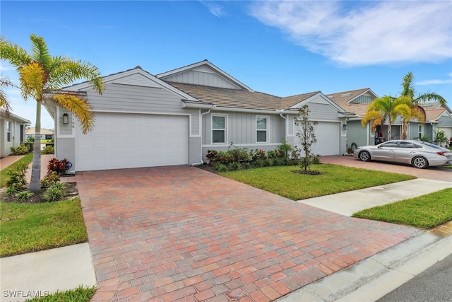 single story home featuring a front lawn and a garage