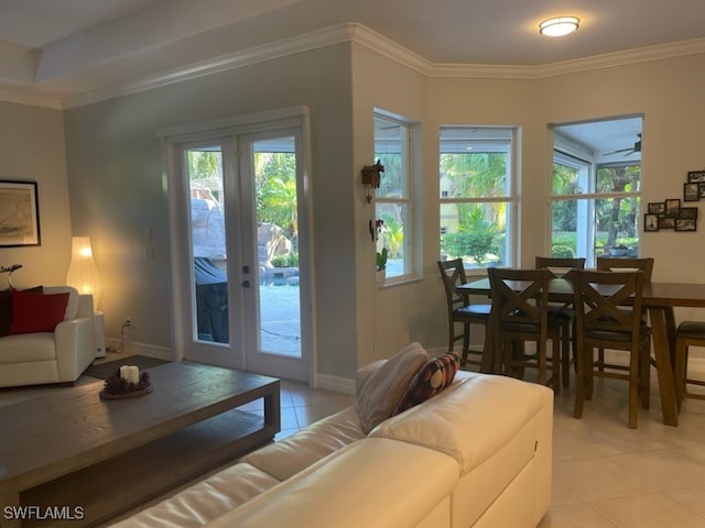 living room featuring french doors, crown molding, light tile patterned floors, and plenty of natural light