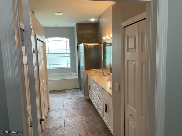 bathroom featuring vanity, tile patterned flooring, and plus walk in shower