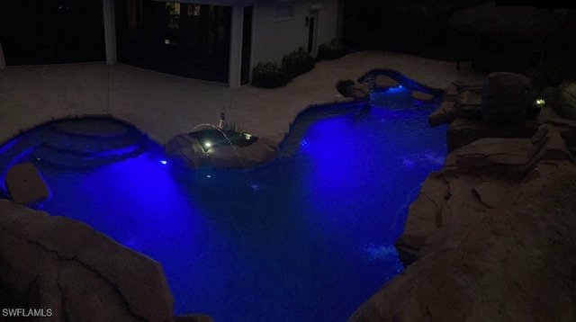 pool at twilight with a patio