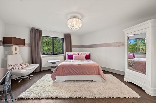 bedroom with dark wood-type flooring and an inviting chandelier