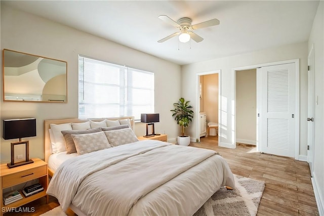 bedroom featuring a closet, light hardwood / wood-style floors, ensuite bath, and ceiling fan