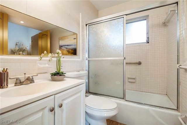 full bathroom featuring shower / bath combination with glass door, decorative backsplash, vanity, and toilet