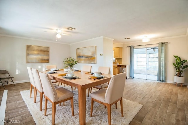 dining area with ceiling fan, light hardwood / wood-style floors, and ornamental molding