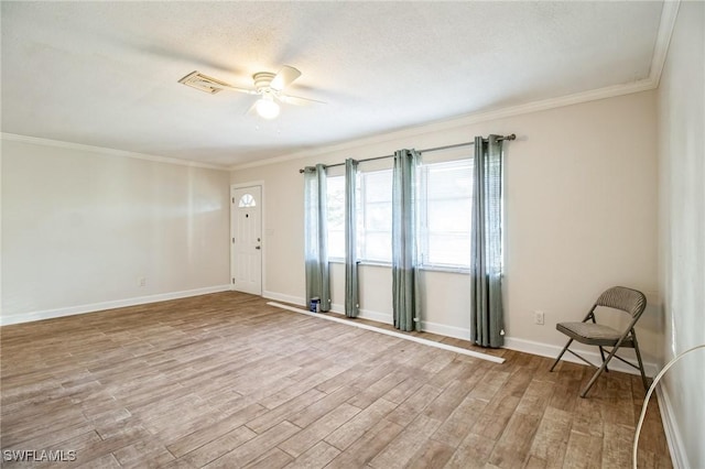 empty room featuring ceiling fan, crown molding, and light hardwood / wood-style floors