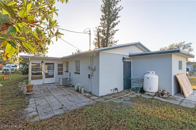 rear view of property with central air condition unit and a patio area