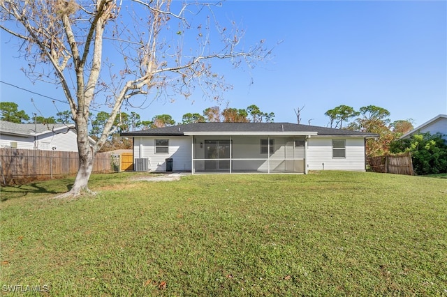 rear view of property featuring a sunroom and a lawn