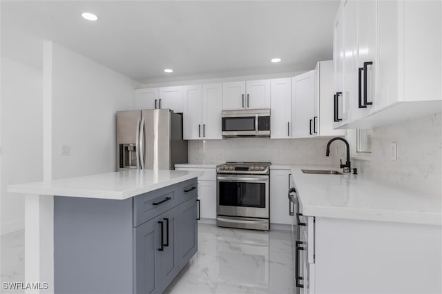 kitchen featuring white cabinets, a kitchen island, sink, gray cabinetry, and stainless steel appliances