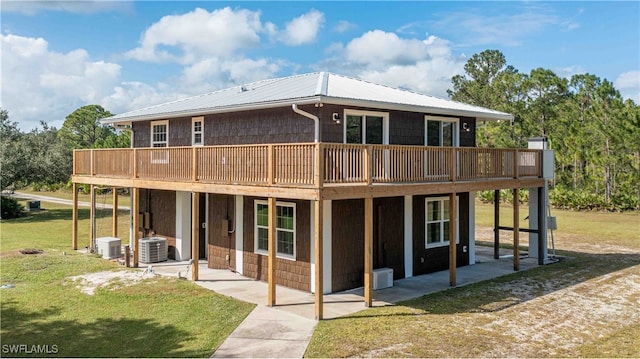 rear view of property featuring a patio area, a deck, a lawn, and central AC unit