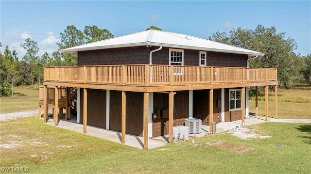 rear view of house with a patio, cooling unit, a wooden deck, and a lawn